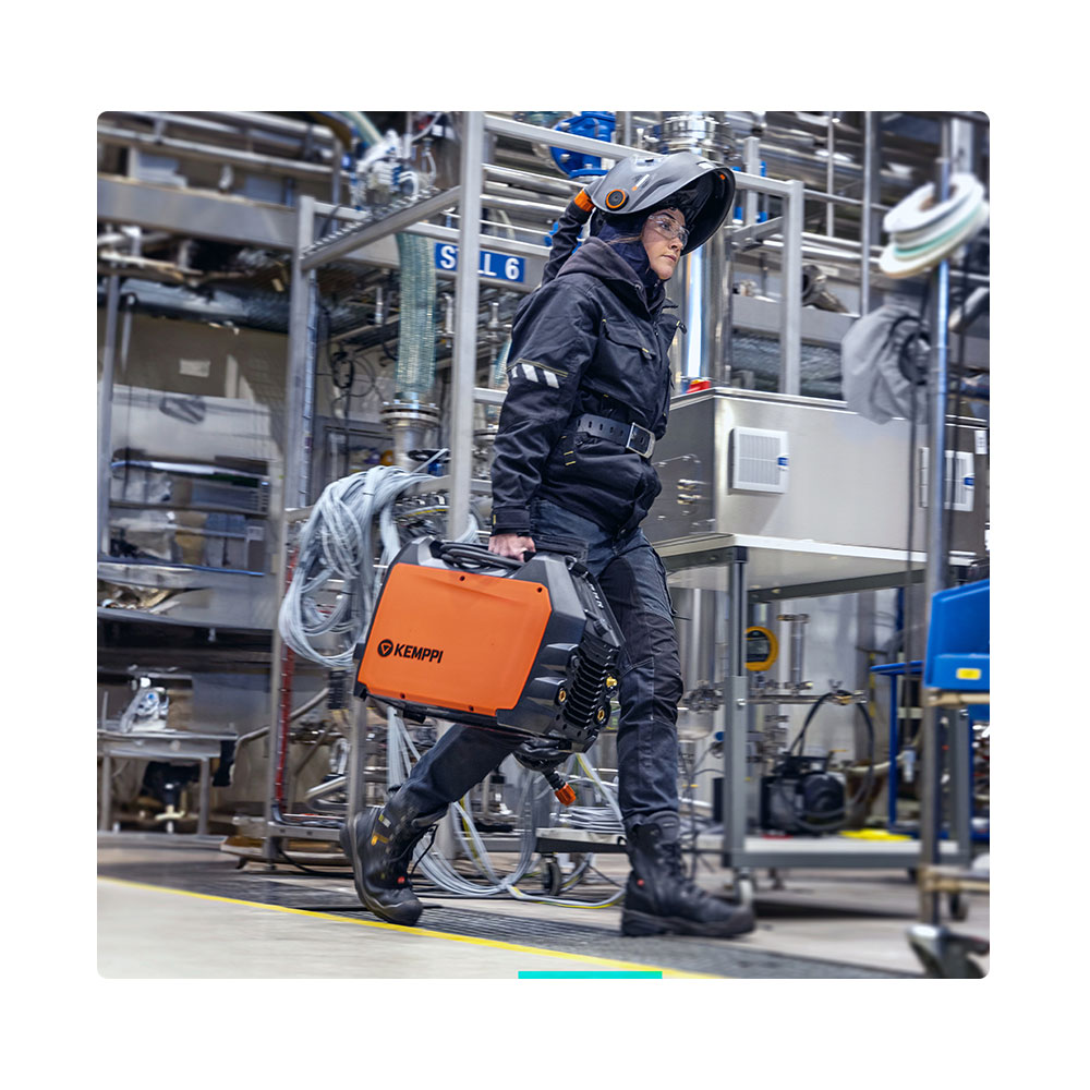 Person carrying welder through factory